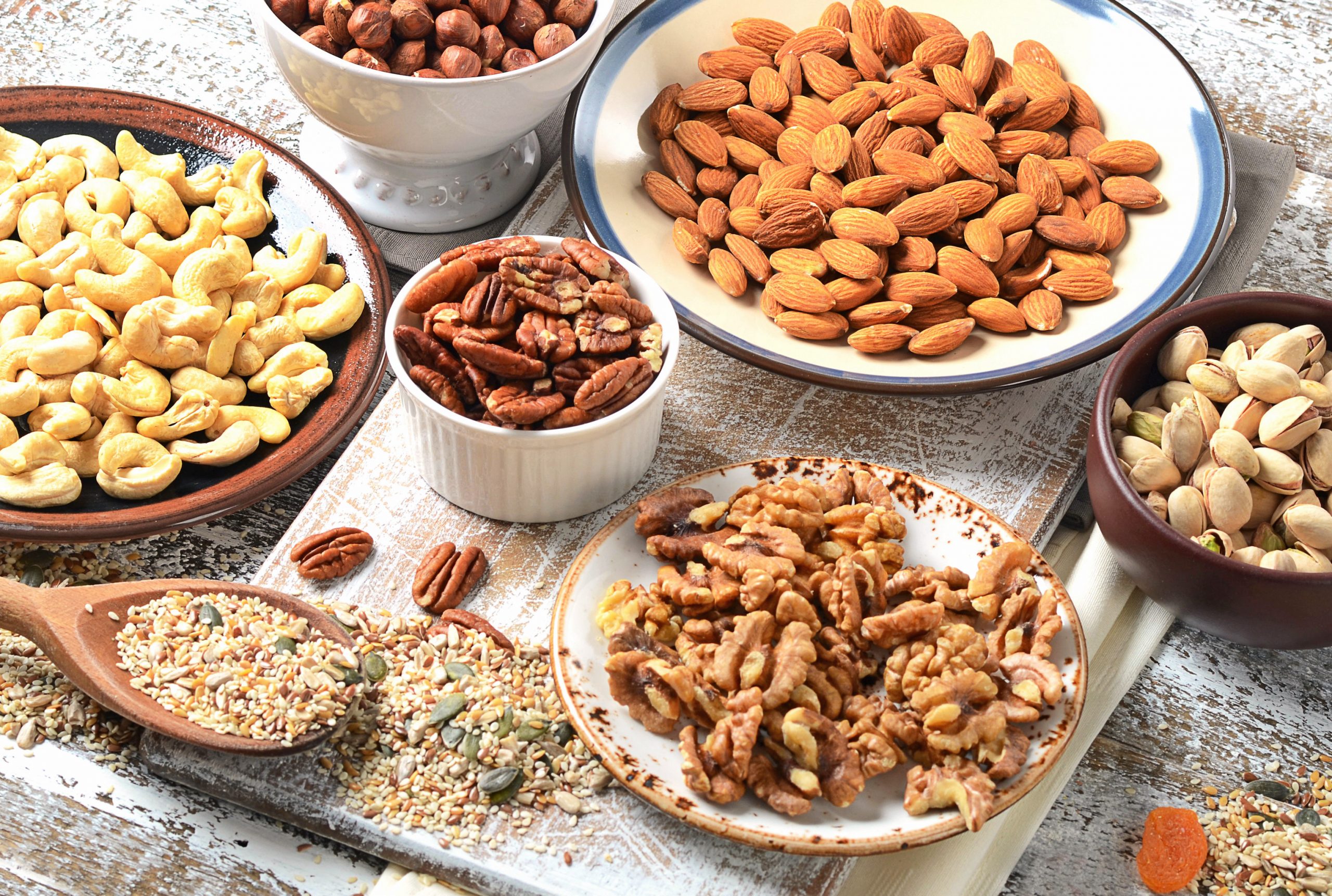 Assorted mixed nuts on wooden table.