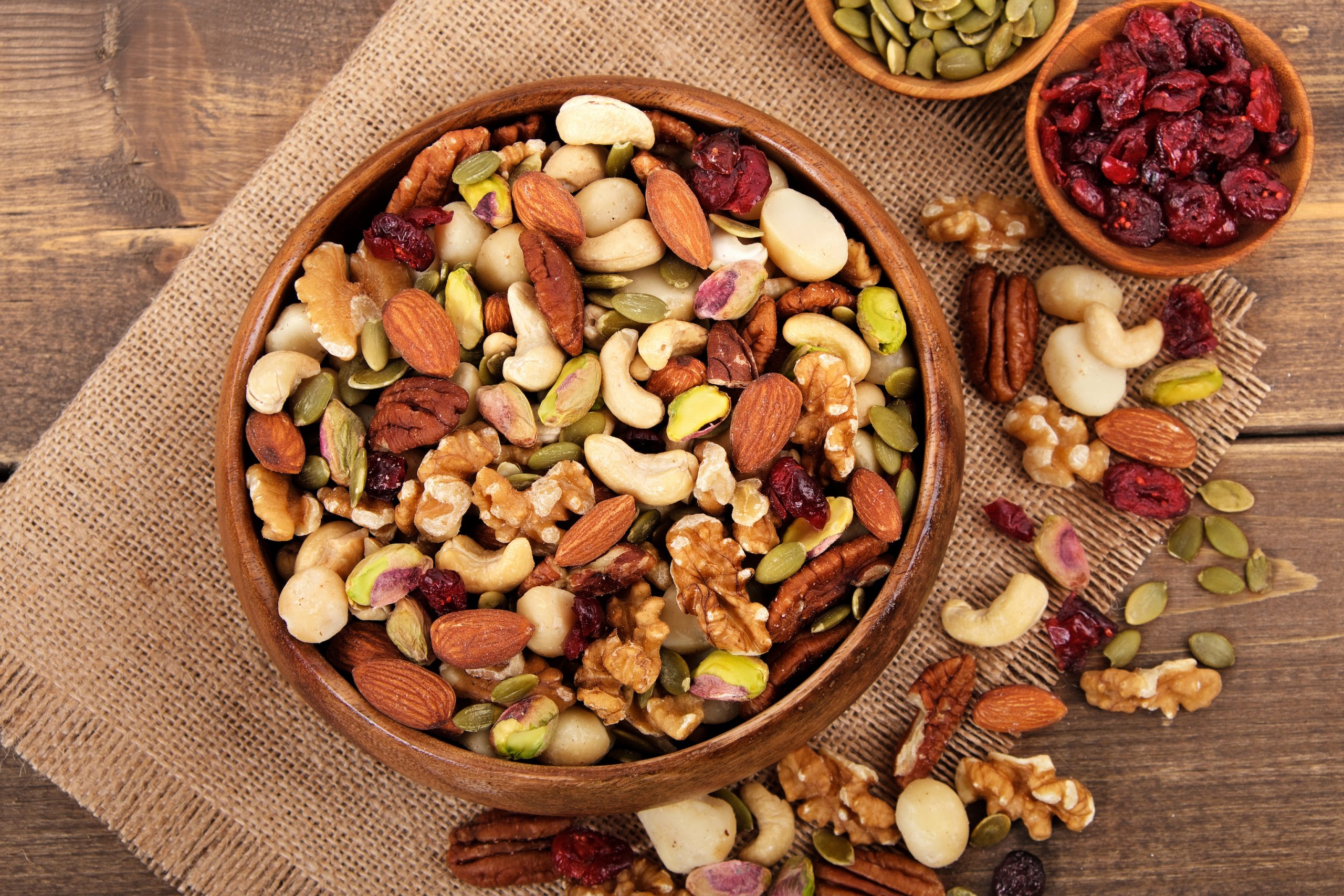 Mixed nuts in wooden bowl with linen mat